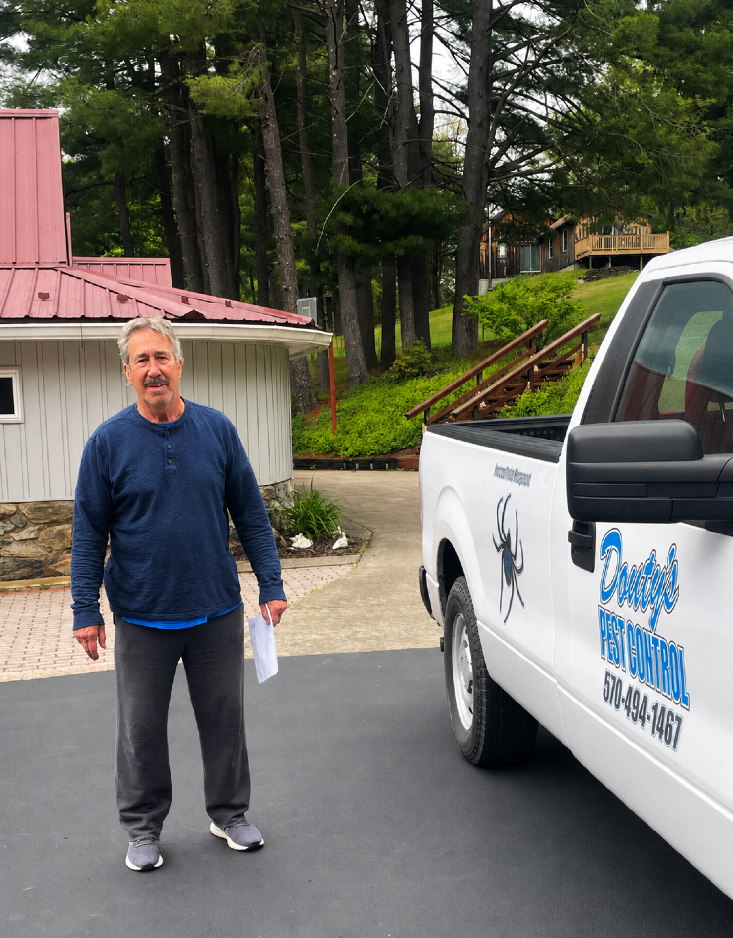 Customer beside a Douty's Pest Control truck after Williamsport spider treatment