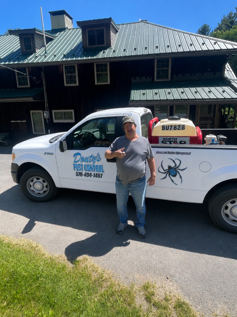 A Douty's technician in front of a branded truck after a residential service call