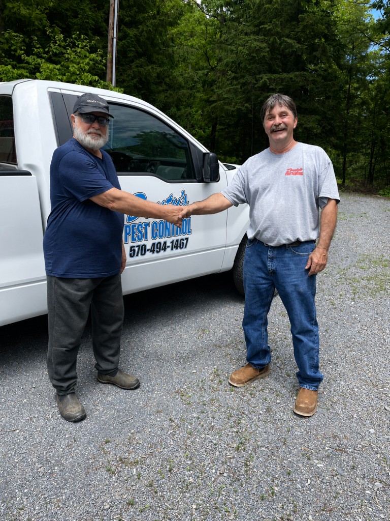 Handshake in front of a Douty's Pest Control truck after a service call