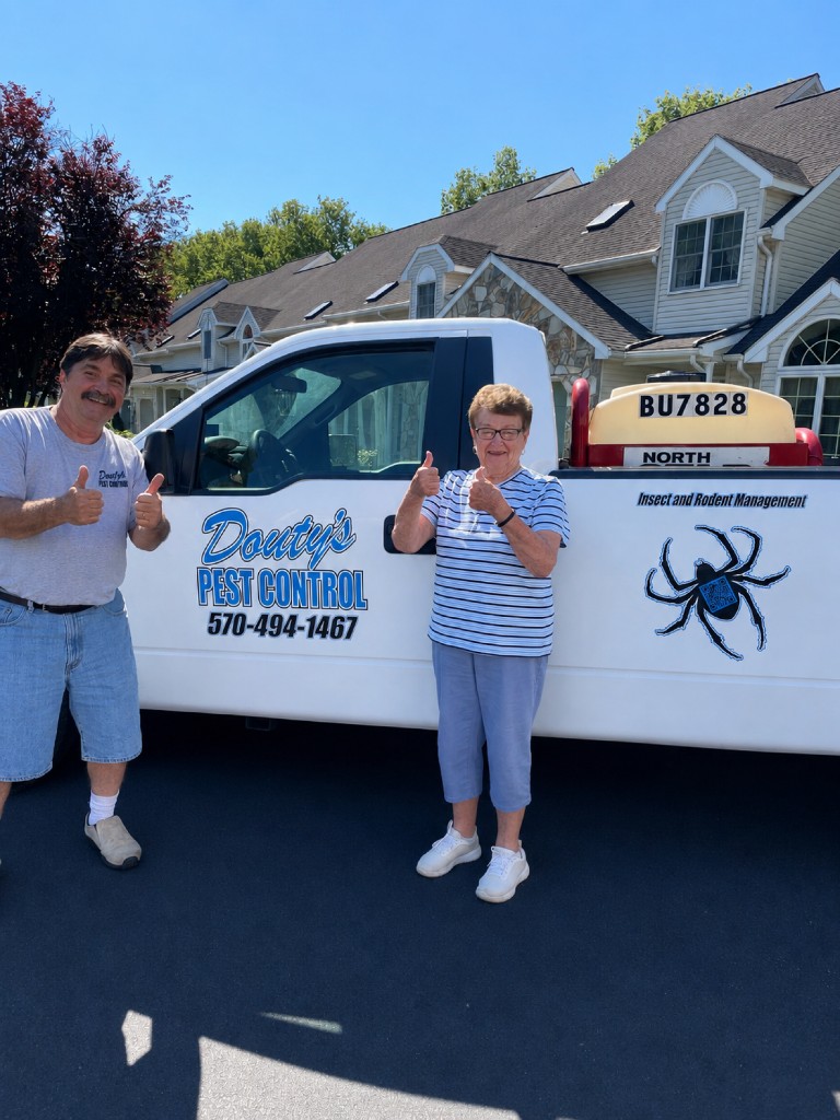A Douty's technician and a customer giving thumbs-up beside a branded service truck