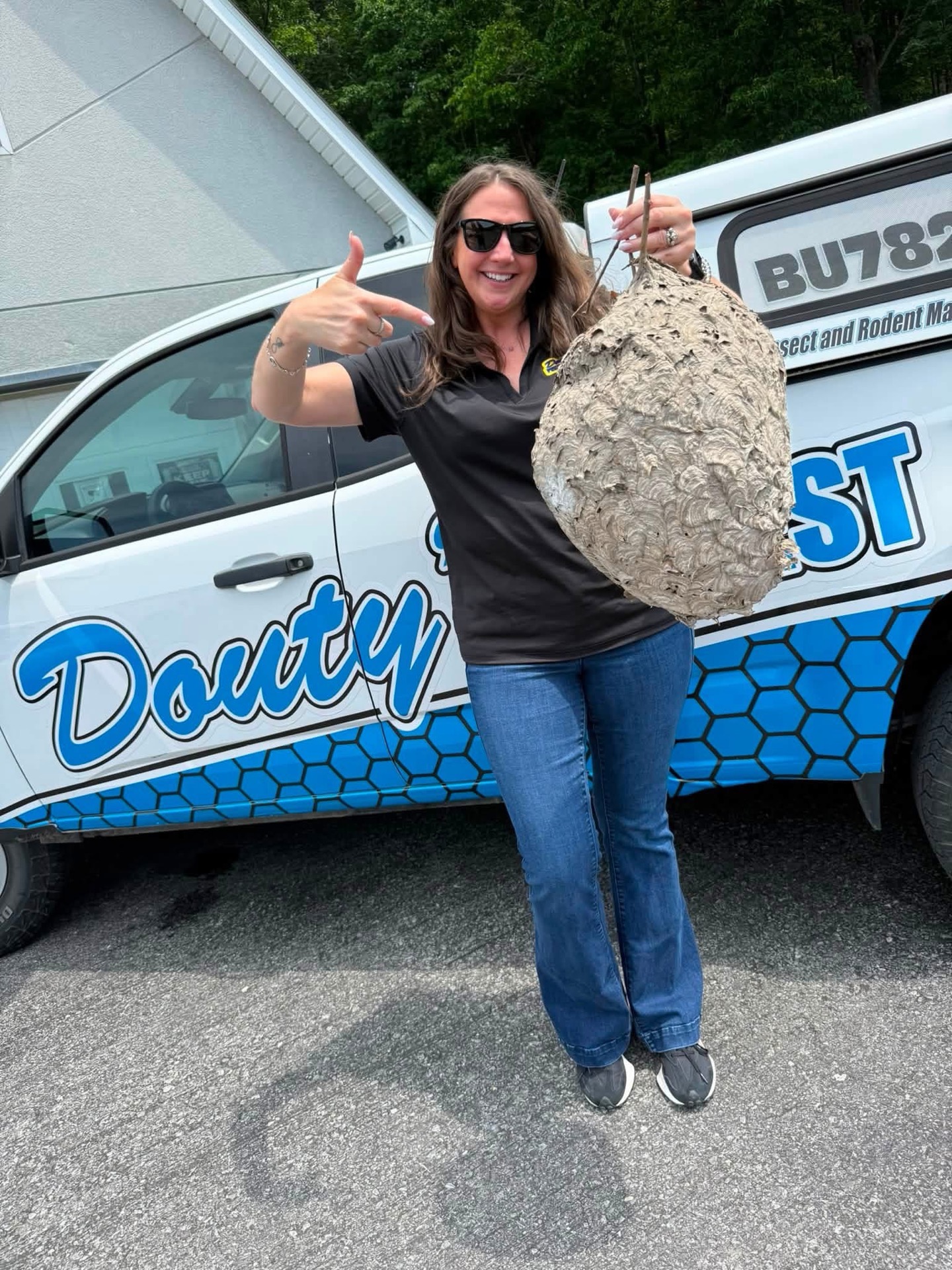 Douty's Pest Control removing a hornet nest from an eave near Muncy, PA